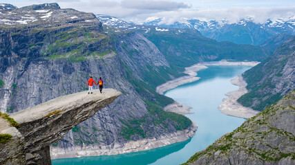 Wall Mural - Couple On A Precipice In Norway, men and women at Trolltunga, Norway