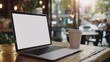 © Keat - Blank laptop screen on wooden table with coffee shop background, template for advertising