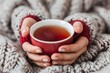 © mangolovemom - A person is holding a red mug of tea while wrapped in a blanket