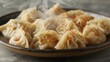 © MakoPoko - A plate of steaming dumplings, the hot vapor curling upwards, emphasizing their deliciously cooked perfection on a plain background.