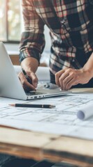 Aufkleber - A man is working on a laptop with a pen and a pencil