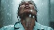 © Vuvimages - A person drenched in rain tilts their face upwards, water droplets streaming down in a dramatic and atmospheric scene that evokes a sense of liberation and renewal.