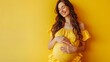© AlfaSmart - Joyful pregnant woman standing against a bright yellow background