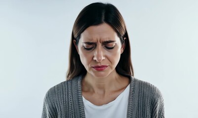 Sticker - Lifestyle portrait video of a woman in her 30s with a somber and deeply sad expression due to major depression wearing a chic cardigan against a white background 