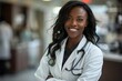 © Yuliia - confident black female doctor in a hospital setting, smiling and portraying empowerment and professionalism.