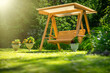 © Svetliy - Wooden garden swing in the green garden in summer.Making garden furniture with your own hands.