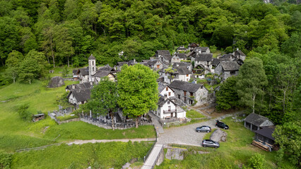 Lush Green Landscape Surrounding Quaint Village in Springtime With Stone Houses and Scenic Pathway