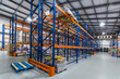 © alhim - Modern Warehouse Interior Featuring Stacked Pallets in a Spacious Storage Facility. A well-organized warehouse interior displays rows of shelving units, filled with neatly stacked pallets.