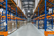 © alhim - Spacious Warehouse Interior With Tall Racking Systems Displaying Stacked Pallets in Business Environment.The interior of a large warehouse features high racking systems filled with neatly stacked pall