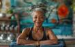 © imagineRbc - An active senior black African woman smiles warmly while practicing yoga, showcasing strength and grace in a vibrant studio