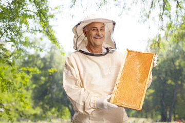 Poster - Bee keeper in a uniform holding a honeybee frame