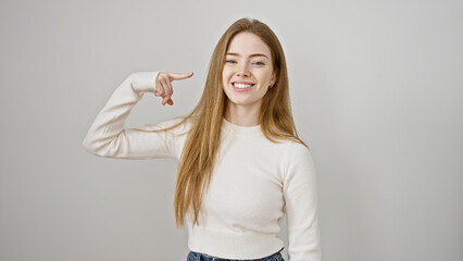 Poster - Smiling young caucasian woman pointing at her face on a white background