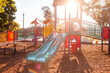 © Austockphoto - Park playground in afternoon light with children playing on slide