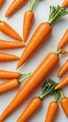 Wall Mural - Fresh, vibrant carrots with green tops arranged on a white background.