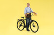 © New Africa - Happy postman with bicycle delivering letters on yellow background