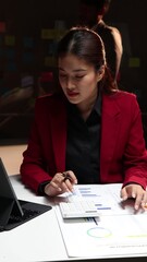 Wall Mural - Businesswoman working overtime in the office at night. Accountants are calculating budgets and planning finances. Accounting for income and expenses.