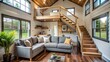 © Caitlin - Cozy tiny house living room features a plush couch facing a staircase leading to a loft, surrounded by natural light and minimalist decor.