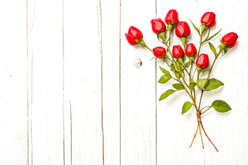 Sticker - Red rosebuds on white wood background