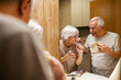 © Dusan Petkovic - Smiling morning senior couple is having morning routine and brushing teeth in a bathroom.