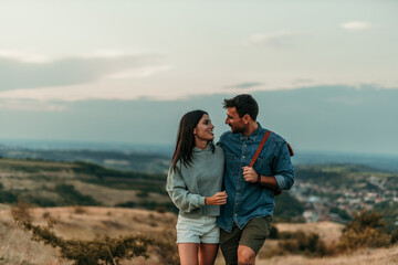 Wall Mural - Happy couple enjoying their summer-autumn walk through the hills. Copy space.