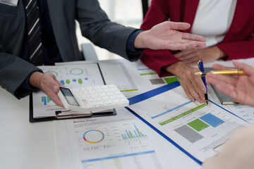 Wall Mural - Asian business people team analyzing and brainstorming using calculators. Hand-pointing financial data on the sheet. Graph Chart showing earnings. growth teamwork process concept.