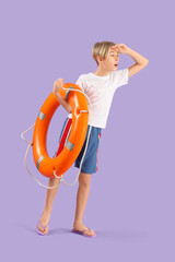 Wall Mural - Shocked little boy lifeguard with ring buoy on purple background