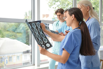 Wall Mural - Female doctors studying MRI scan in clinic