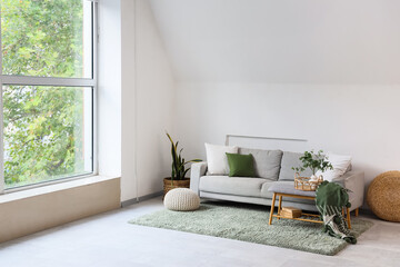 Poster - Interior of light living room with grey sofa, soft bench and poufs