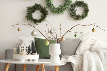 Wall Mural - Vase with tree branches, Christmas balls and candles on tables in living room