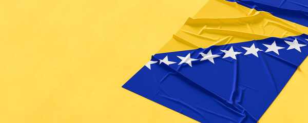 Flag of Bosnia and Herzegovina. Fabric textured Bosnia and Herzegovina flag isolated on yellow background. 3D illustration