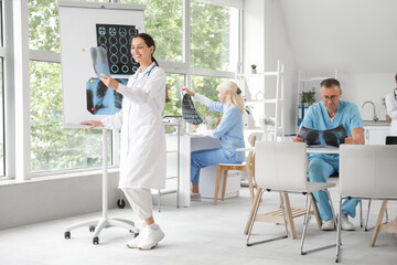 Canvas Print - Group of doctors studying x-ray images in clinic