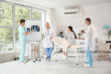 Wall Mural - Doctors studying patient's x-ray image of lungs in clinic