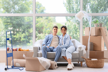 Canvas Print - Young couple sitting in room on moving day