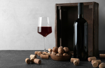 Wall Mural - Glass of wine, walnuts and corks on dark table