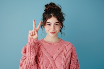 Poster - A person posing with a peaceful gesture, wearing a bright pink sweater