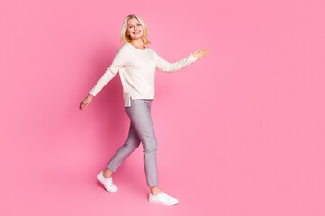 Sticker - Photo of nice lovely senior woman wear stylish clothes go empty space isolated on pink color background