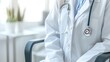 © Aleena - White doctor's coat with stethoscope hanging on chair in medical office, closeup, blurred background, copy space concept for business and healthy lifestyle.