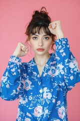 Wall Mural - A woman posing for a photo wearing a bright blue floral shirt