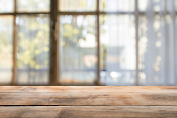 Poster - Empty wooden table top is presenting a blurred window background with a view of trees in the garden