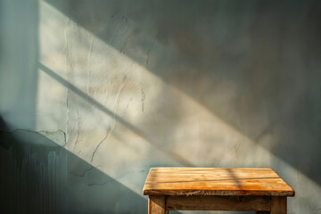 Poster - Empty wooden table casting shadow on a sunlit grunge wall, perfect for product placement or showcasing