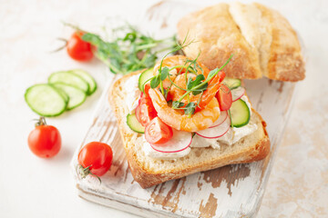 Wall Mural - Sandwich with vegetables and prawns on a wooden board. Ciabatta sandwich