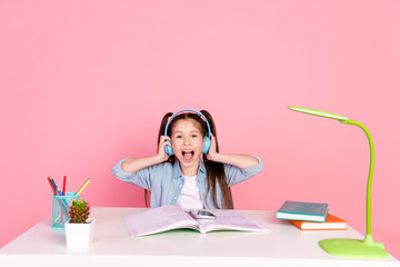 Sticker - Photo of cute girl dressed shirt sit down table in headphones listen music on smartphone sing song isolated on pink color background