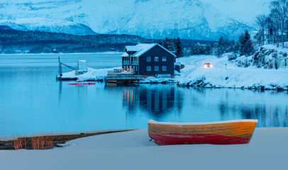 Wall Mural - red wooden boat covered with layers of snow - beautiful winter landscape with snow covered red house