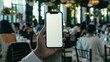 © MD Media - Mockup of a blank smartphone, mobile phone screen held in hand, wedding reception room scene scene background. Flowers wedding dress and bride, groom and guests