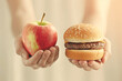 © forenna - Hands holding an apple and a hamburger: contrasting healthy organic fruit with unhealthy processed fast food, nutrition lifestyle choices, fitness diet balance, wellness eating dec