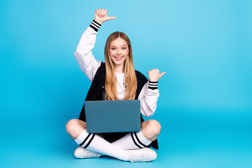 Poster - Photo of adorable pretty girl wear trendy clothes long socks presenting empty space isolated on blue color background