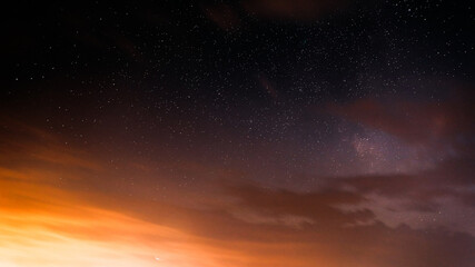 Wall Mural - Sunset Evening Bright Sky And Glowing Stars. Natural Background Backdrop In Yellow And Black Colors. Copyspace. space stars starlight Starry sky universe panoramic view panorama