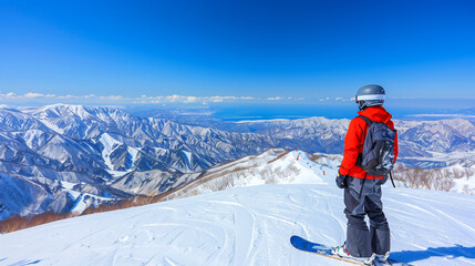 Wall Mural - Man with snowboard standing on snowy mountain