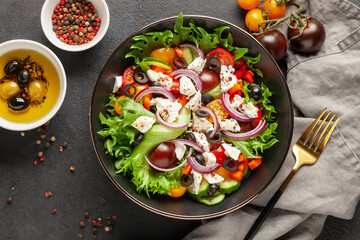 Wall Mural - Greek salad of fresh cucumber, tomato, sweet pepper, red onion, feta cheese and olives with olive oil. Healthy food. Top view