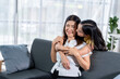 © Wasana - Two women are hugging each other on a couch
